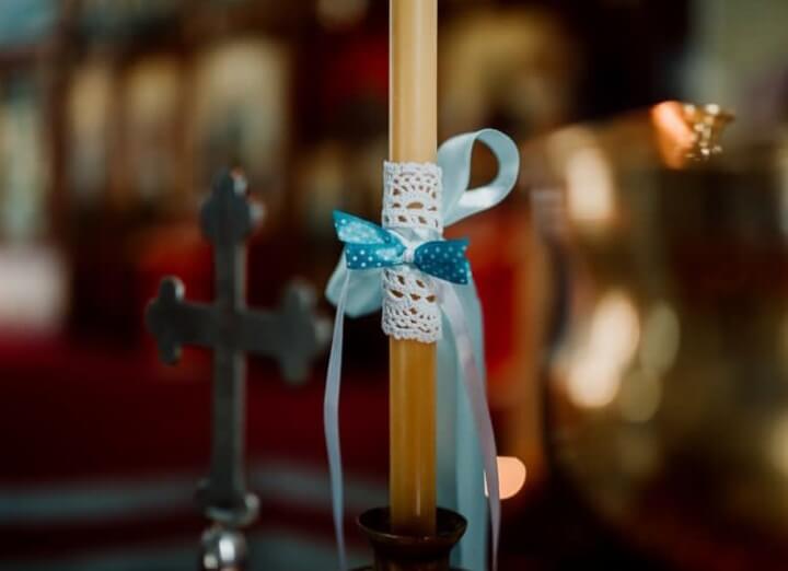 na slici su sveća i krst u crkvi