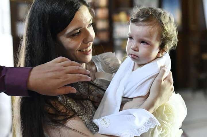majka drži dete i ruka koja želi da ga dodirne