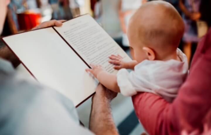 beba dodiruje bibliju u crkvi