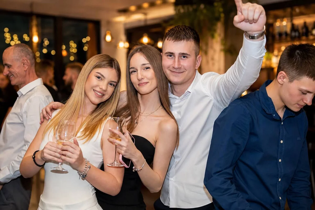 Prijatelji uživaju na proslavi u restoranu uz piće i veselu atmosferu