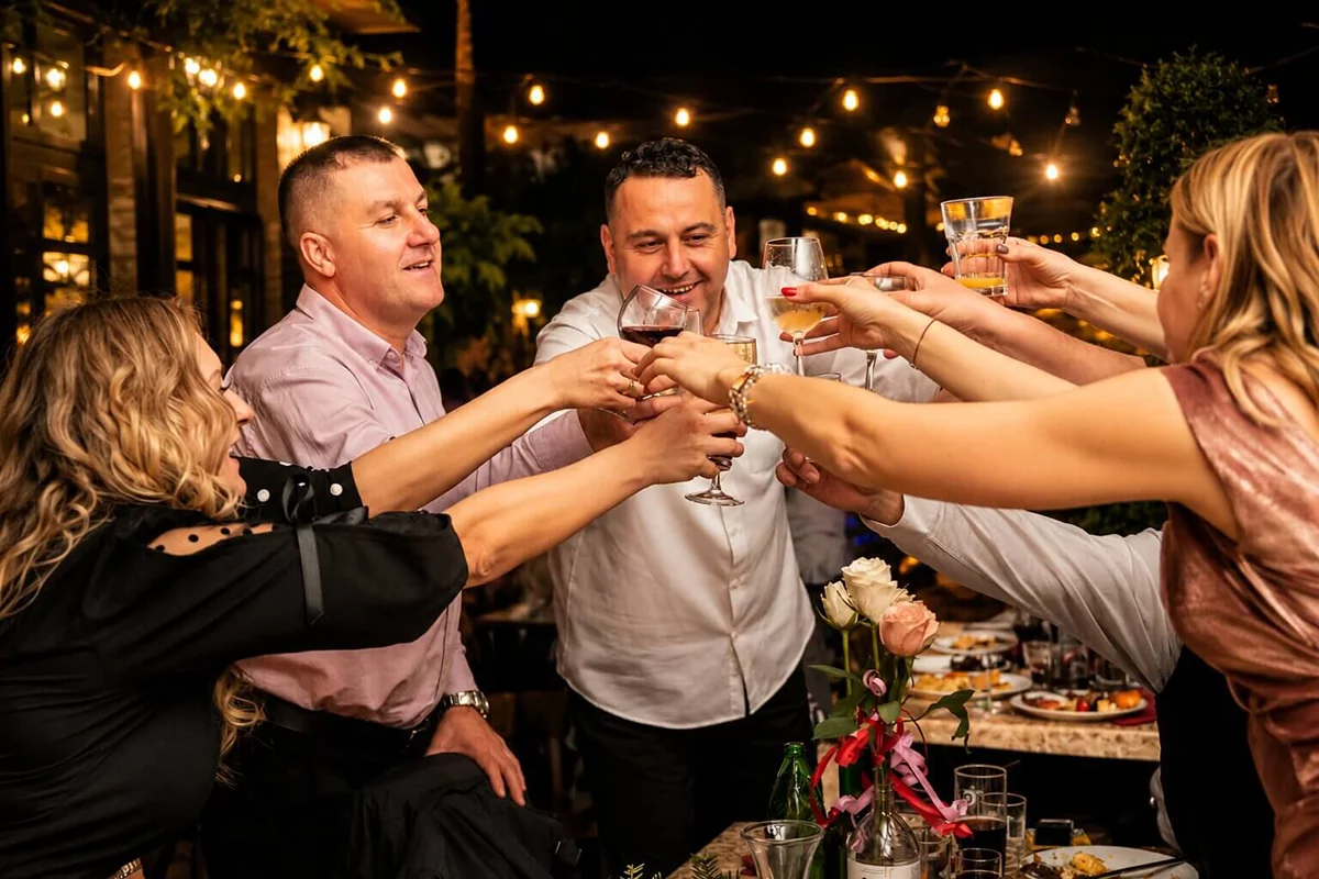 Gosti nazdravljaju na večernjoj proslavi u bašti restorana uz prijatnu atmosferu