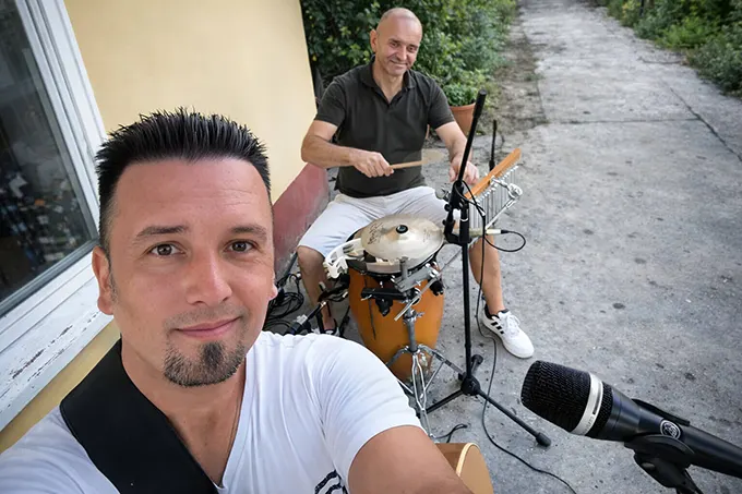 Članovi akustičnog benda – gitarista i perkusionista tokom pripreme za nastup na proslavi.